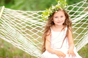 small child sitting in a hammock with a flower crown for photography in Fort Carson