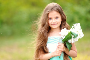 young child outside and holding a bundle of flowers, outdoor photographer, portrait photographer, outdoor photography, portrait photography